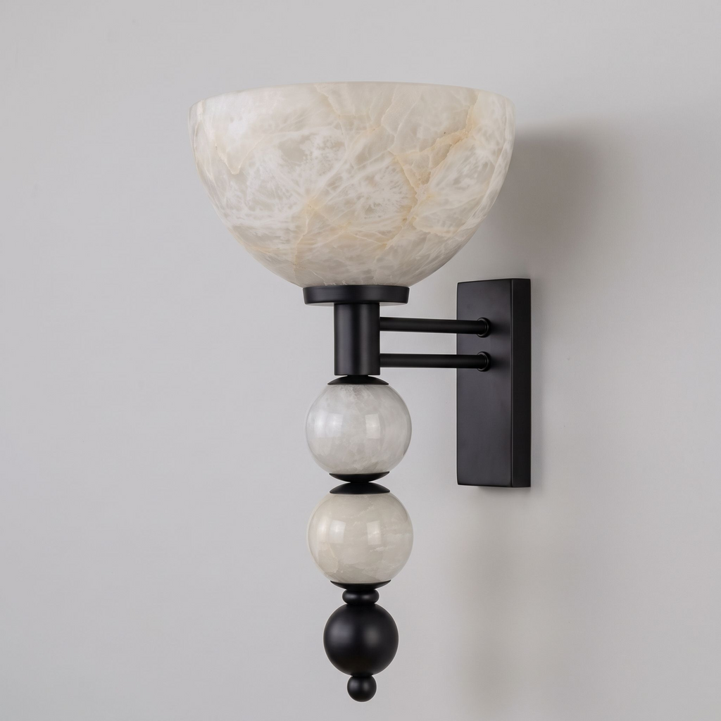 Close on black hardware, this Clérachic sconce reveals its alabaster bowl shade and two stacked spheres against grey.