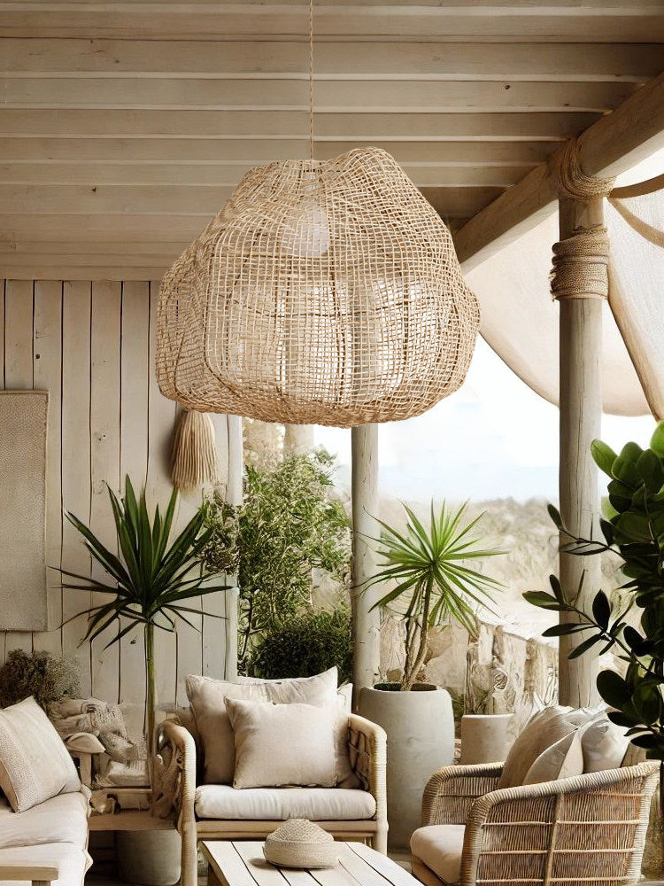 On a covered porch beneath wood beams, this Clérachic pendant hangs among potted plants and wicker chairs.