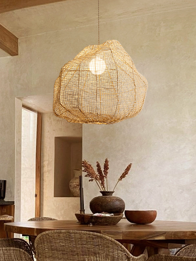 Near a rustic plaster doorway, this Clérachic pendant hangs above a wood table with a dark bowl and dried stems.