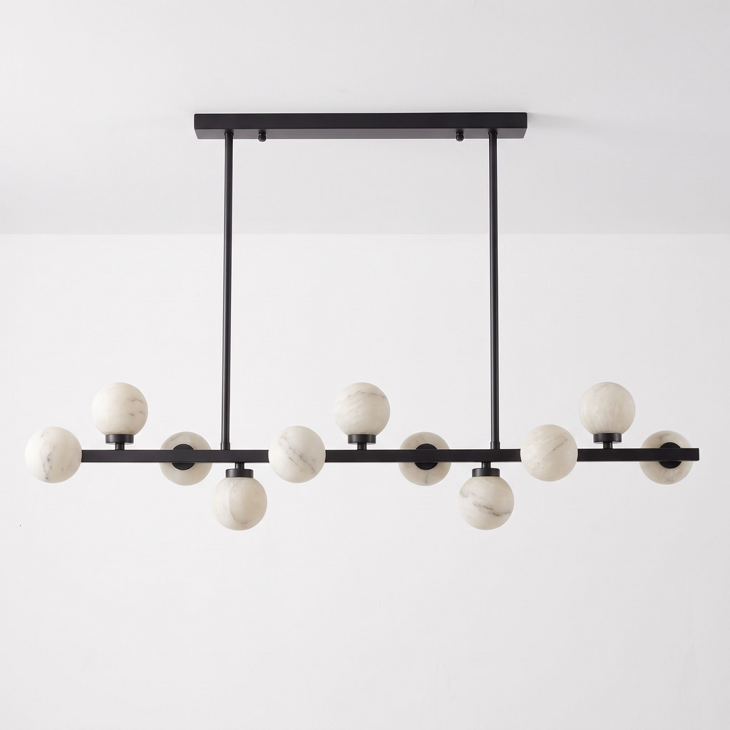 This Clérachic chandelier in matte black is shown on a plain backdrop, its balls staggered along the bar.