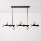 This Clérachic chandelier in matte black is shown on a plain backdrop, its balls staggered along the bar.