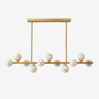 Studio view of this Clérachic chandelier in brushed brass, alabaster balls staggered along a straight bar.