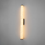Slim alabaster wall sconce mounted beside a doorway