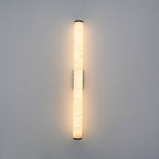 Black-arm alabaster wall sconce mounted on a dark feature wall