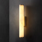 Matte black wall sconce with natural stone shade by a bedside