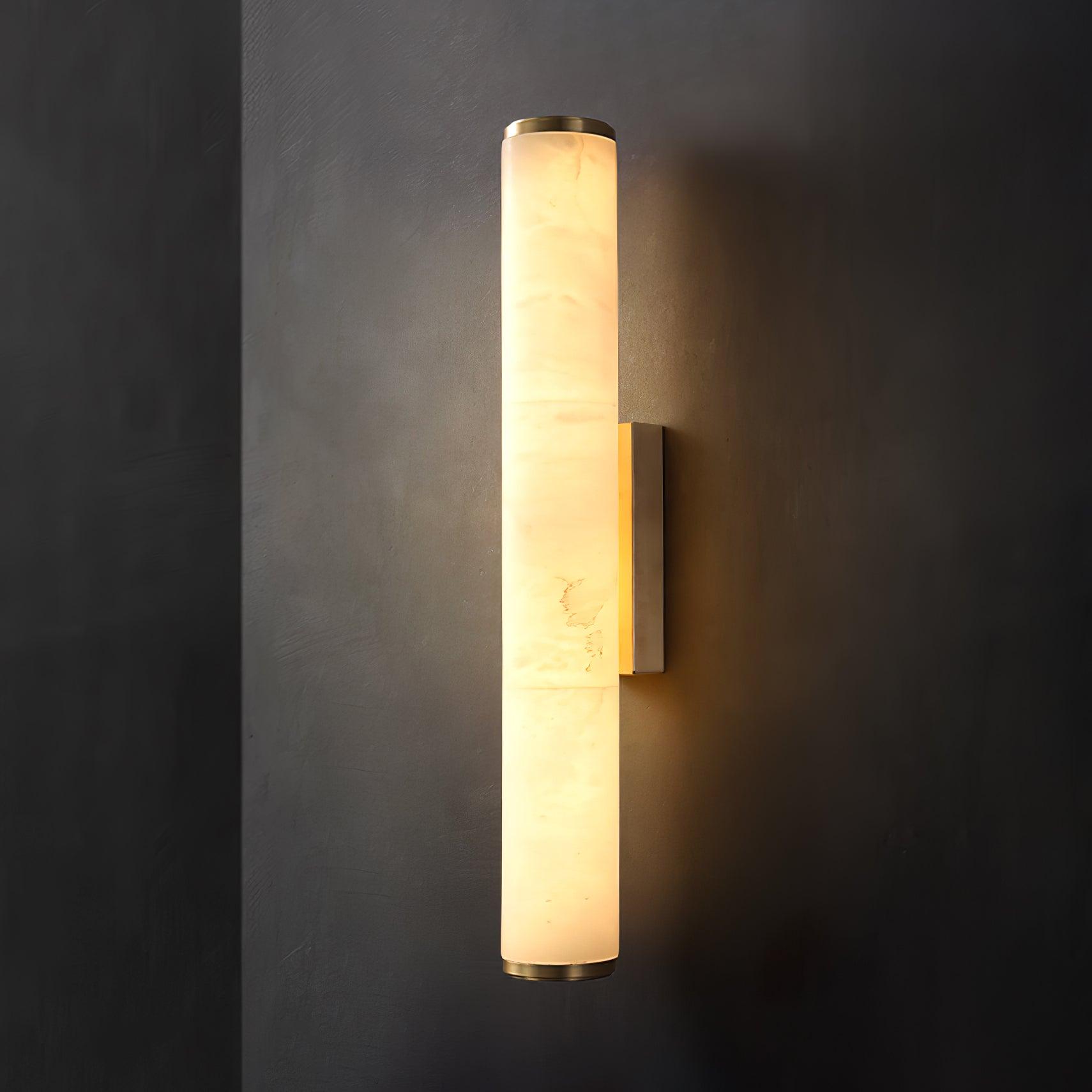 Matte black wall sconce with natural stone shade by a bedside