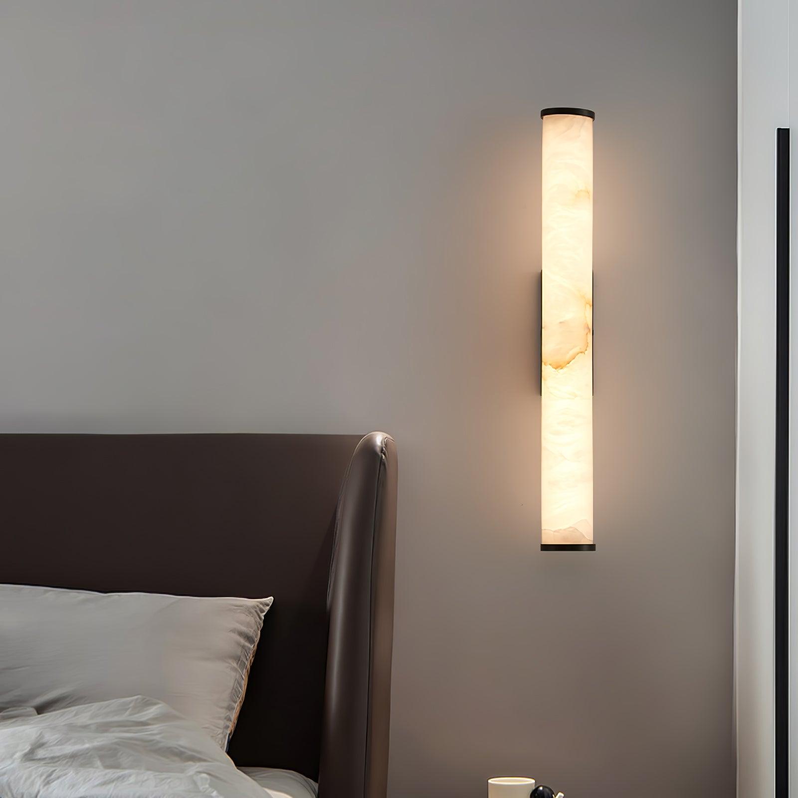 Alabaster wall sconce glowing softly in a darkened room