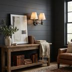 Against dark shiplap panelling, this matte black Clérachic wall sconce lights a rustic console vignette.
