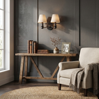 On a charcoal panelled wall, this matte black Clérachic wall sconce glows above a reclaimed-wood console table.