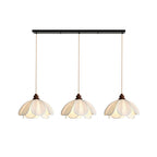 Three shades of this Clérachic pendant hang lit from a black linear bar against a plain backdrop.