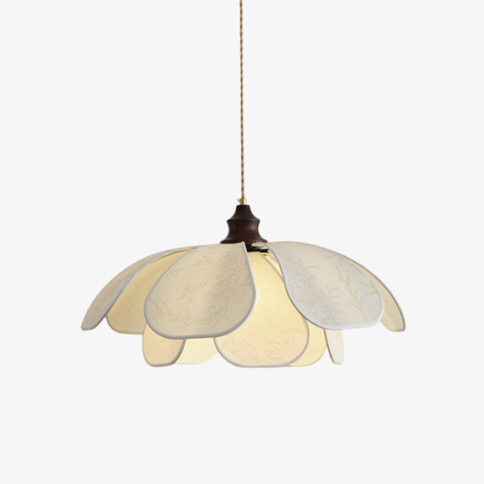 On a plain backdrop, this Clérachic pendant shows its layered fabric petals and walnut collar on a twisted cord.