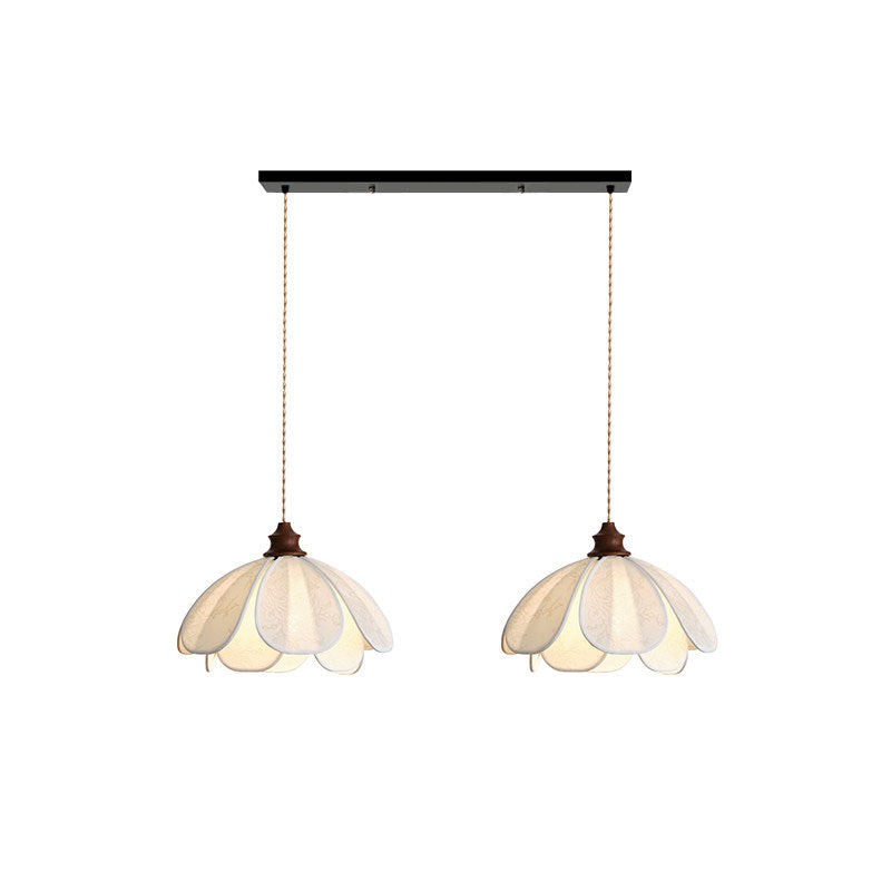Two shades of this Clérachic pendant hang from a black linear bar, unlit on a plain background.