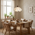 Curtained windows and potted herbs frame this lit Clérachic pendant above a table set for dinner.