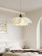 In a white bedroom with an arched doorway, this Clérachic pendant glows above an unmade bed.