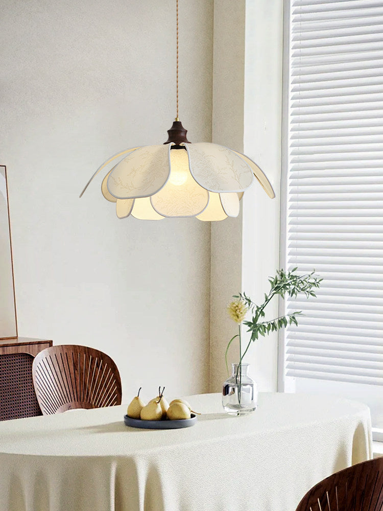 Pears in a bowl and a sprig in a vase sit beneath this close, lit Clérachic pendant.