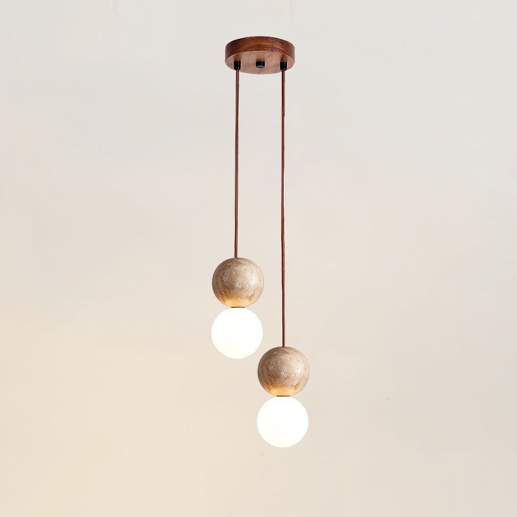 Two cords of differing length drop travertine and glass spheres from this Clérachic pendant's round canopy, studio shot.