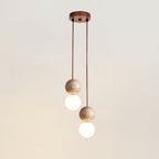 Two cords of differing length drop travertine and glass spheres from this Clérachic pendant's round canopy, studio shot.