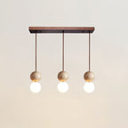 Three travertine and glass spheres line up beneath a long canopy on this Clérachic pendant, studio shot on white.