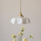 Pleated glass pendant light with soft toned shade and brass body