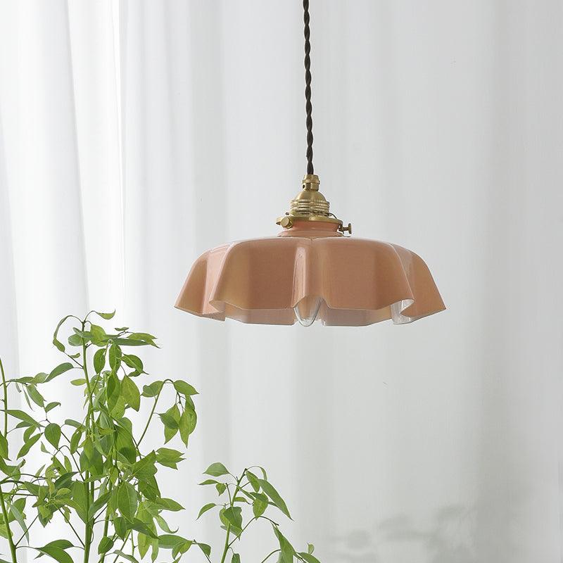 French pendant light with pleated glass shade glowing softly