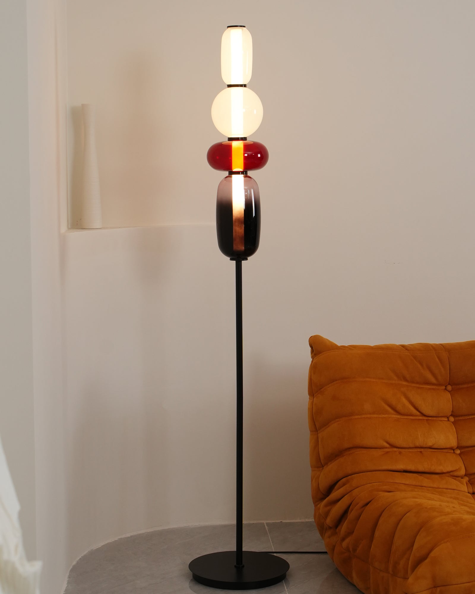 Hand-blown glass floor lamp standing in a bright living space
