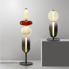 Black-body floor lamp with hand-blown glass clusters near a window