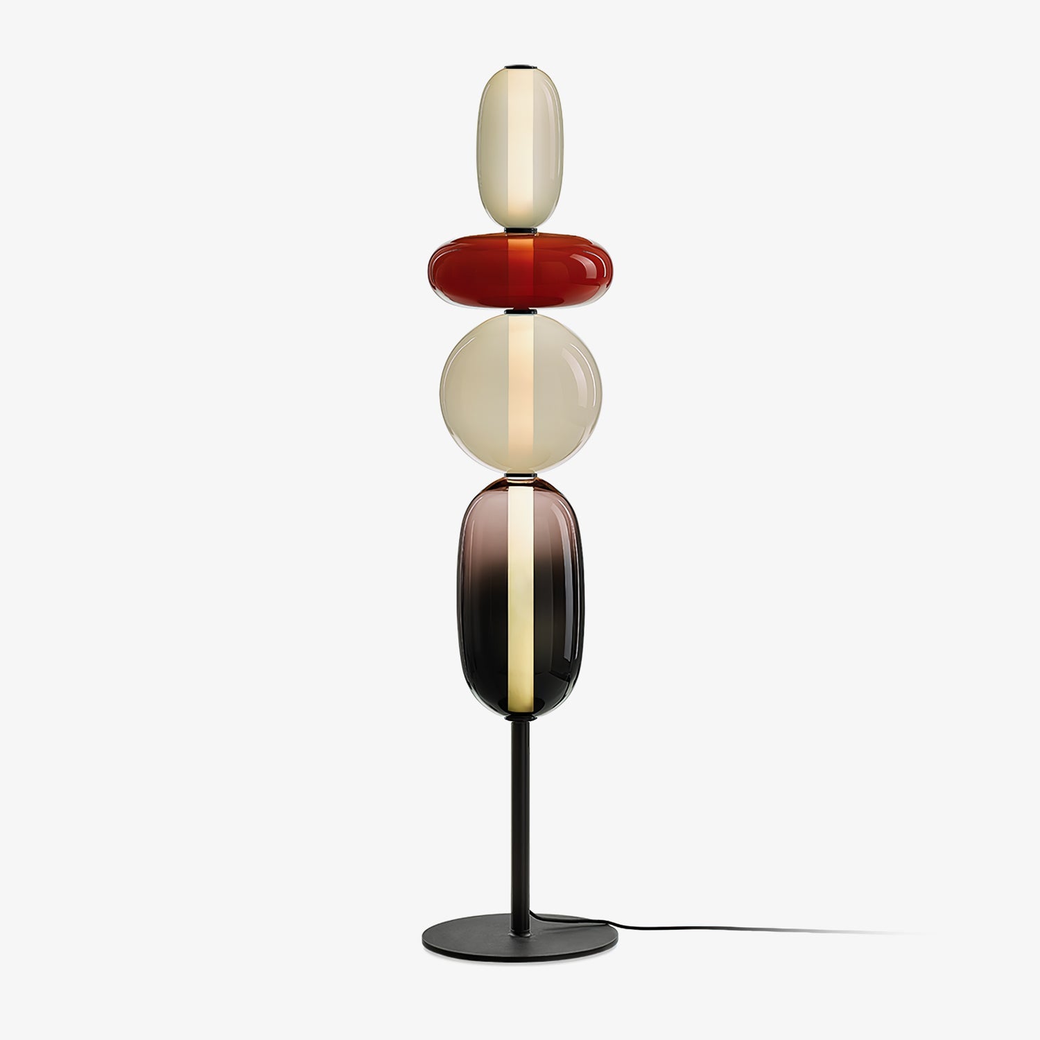 Hand-blown glass floor lamp casting warm light on a wall