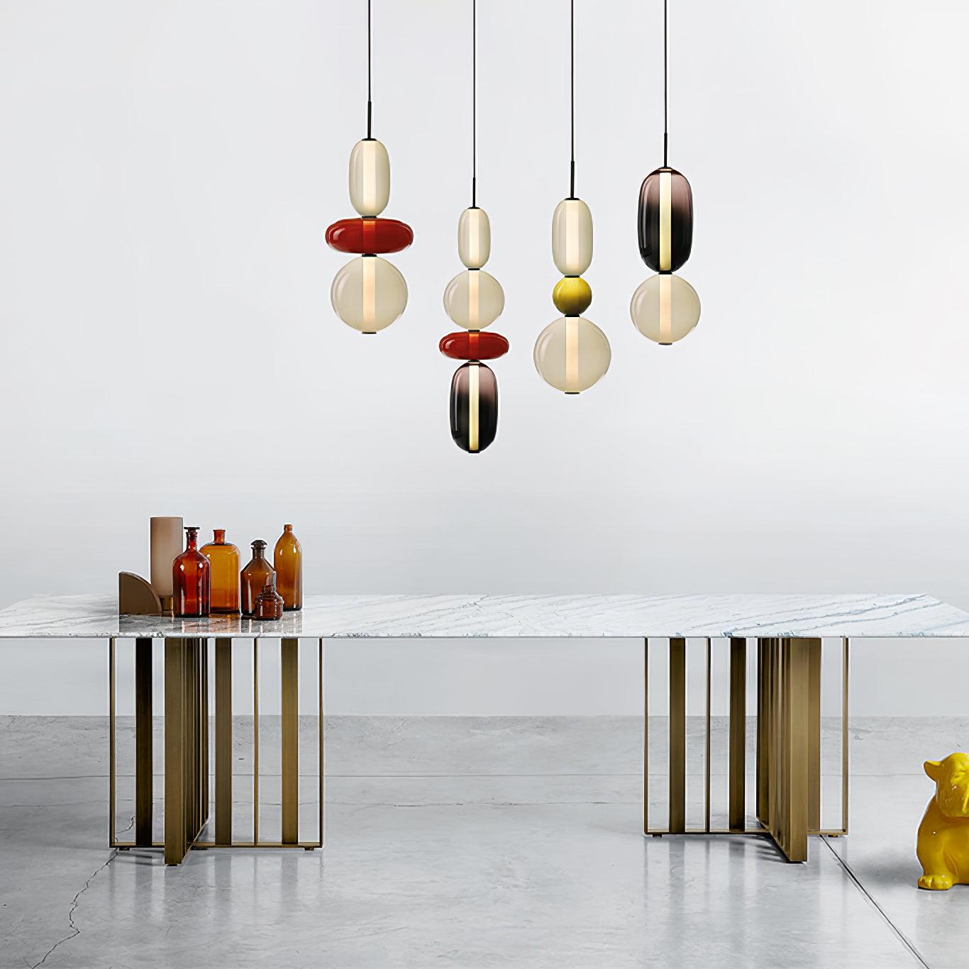Coloured glass jar pendant lights grouped over a table