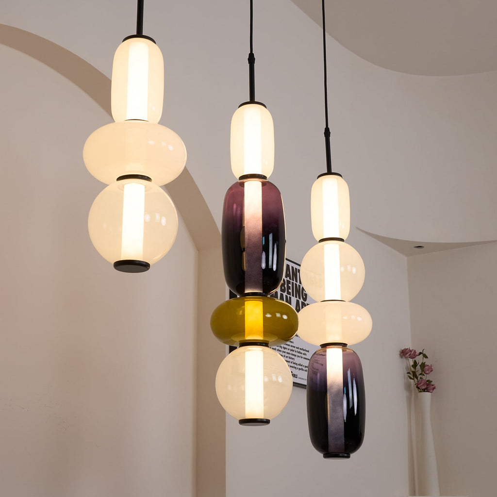 Coloured glass jar pendant lights glowing side by side