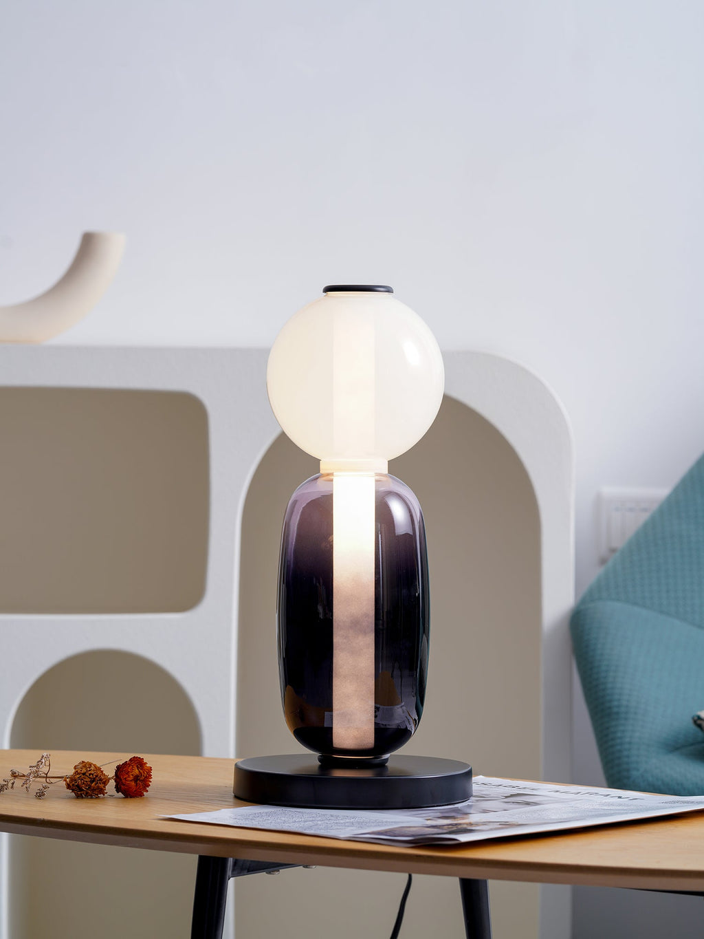 Hand-blown glass table lamp detail with warm glowing pebbles
