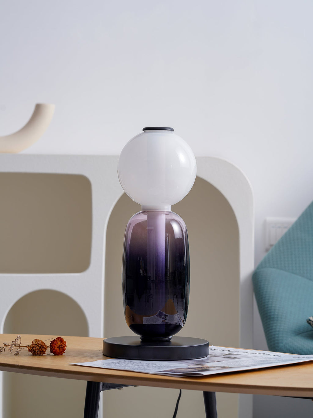 Hand-blown glass pebble table lamp on a slim black base
