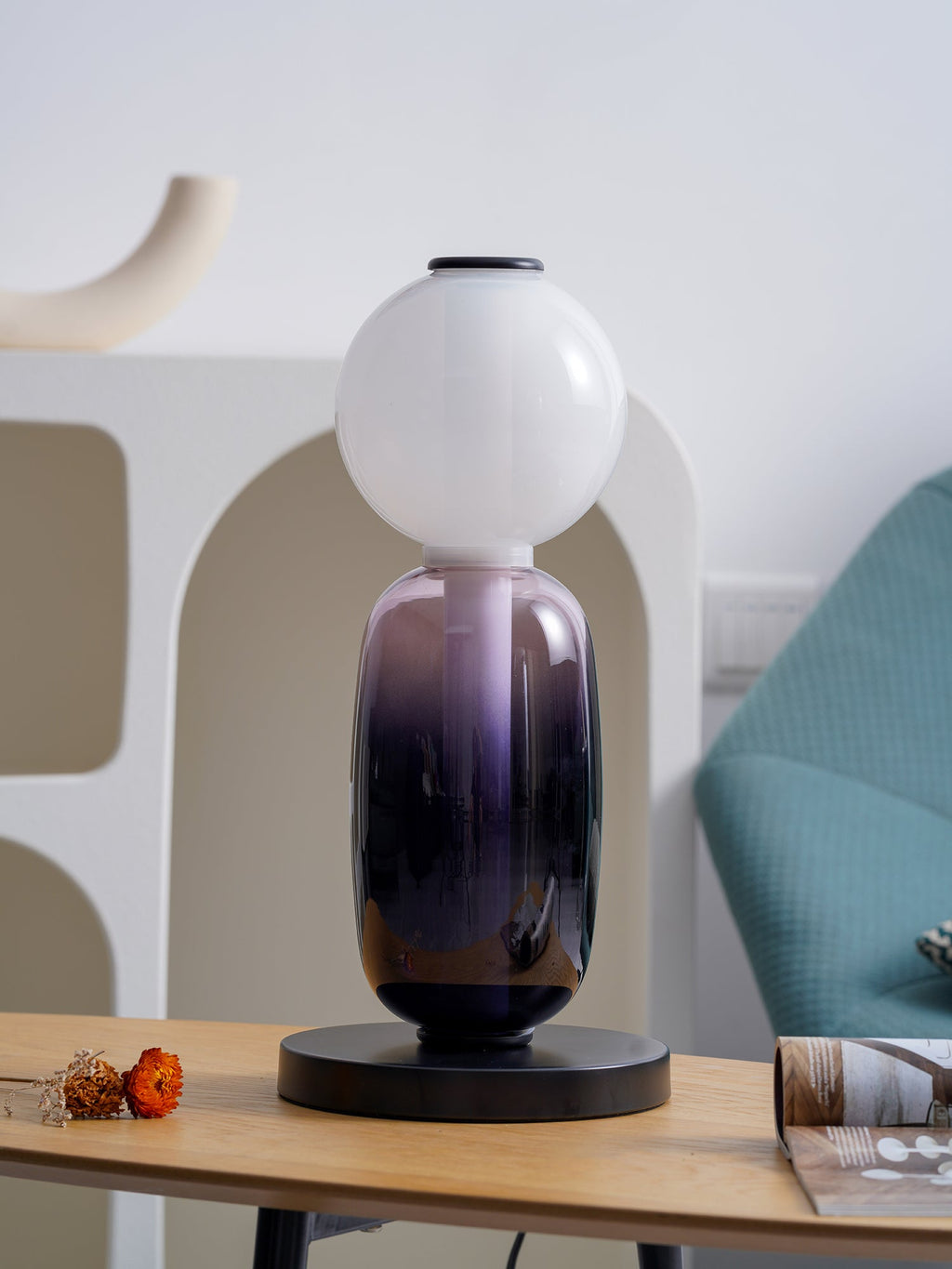 Crystal pebble table lamp casting gentle light on a shelf