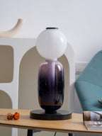 Crystal pebble table lamp casting gentle light on a shelf