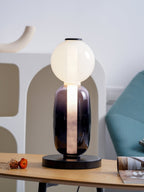 Hand-blown crystal table lamp glowing on a bedside surface