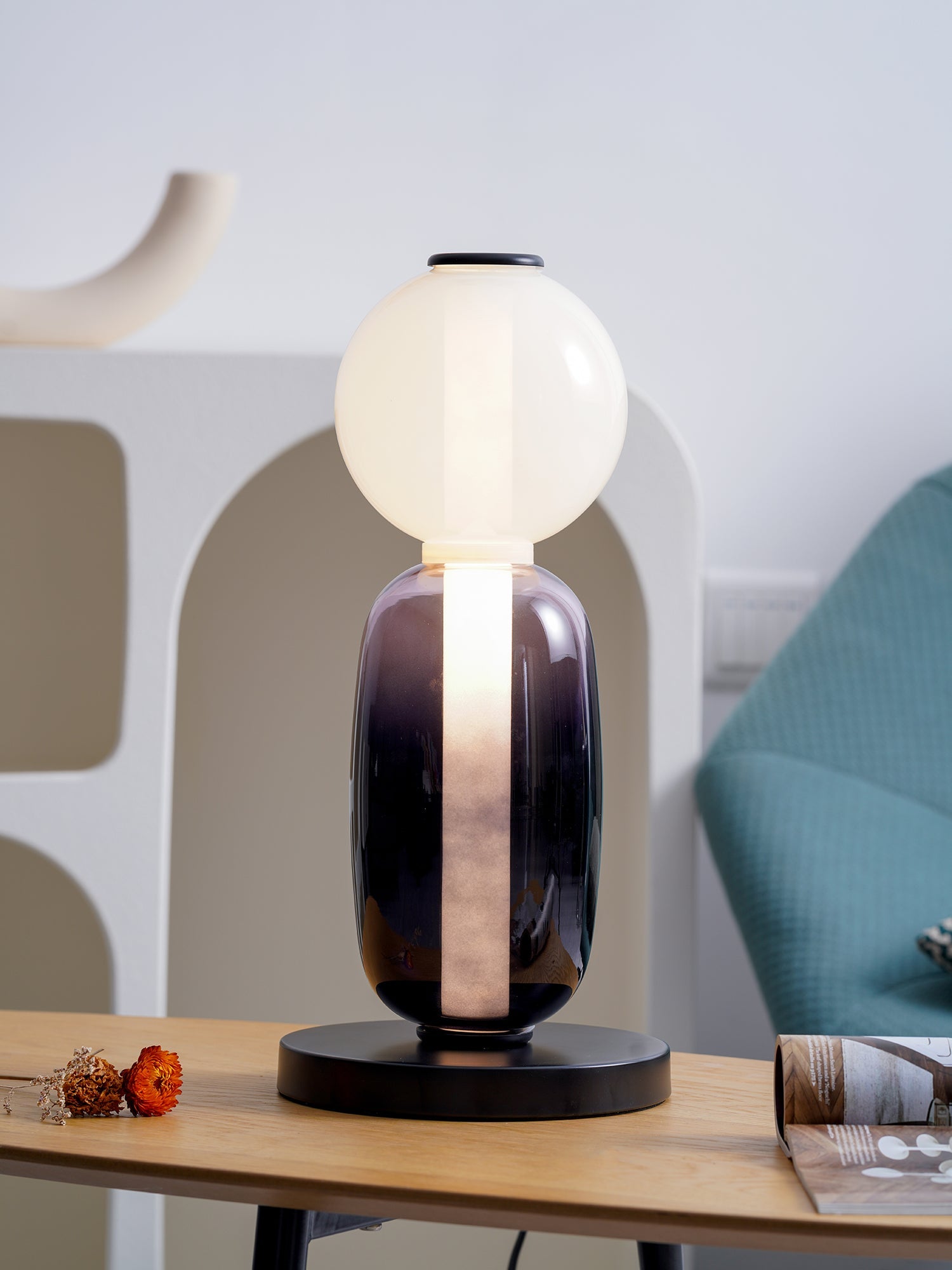 Hand-blown crystal table lamp glowing on a bedside surface