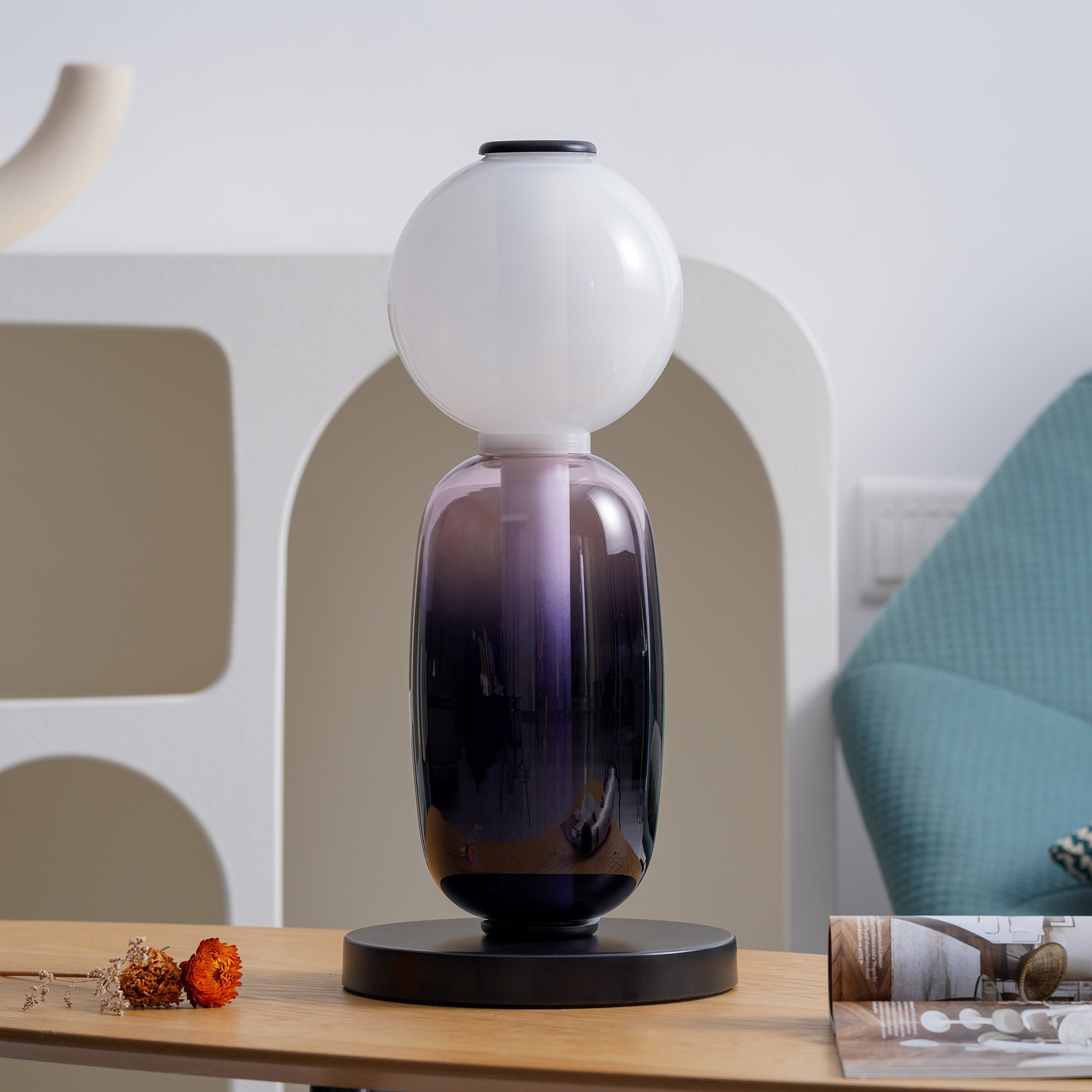 Hand-blown glass table lamp glowing in an evening interior