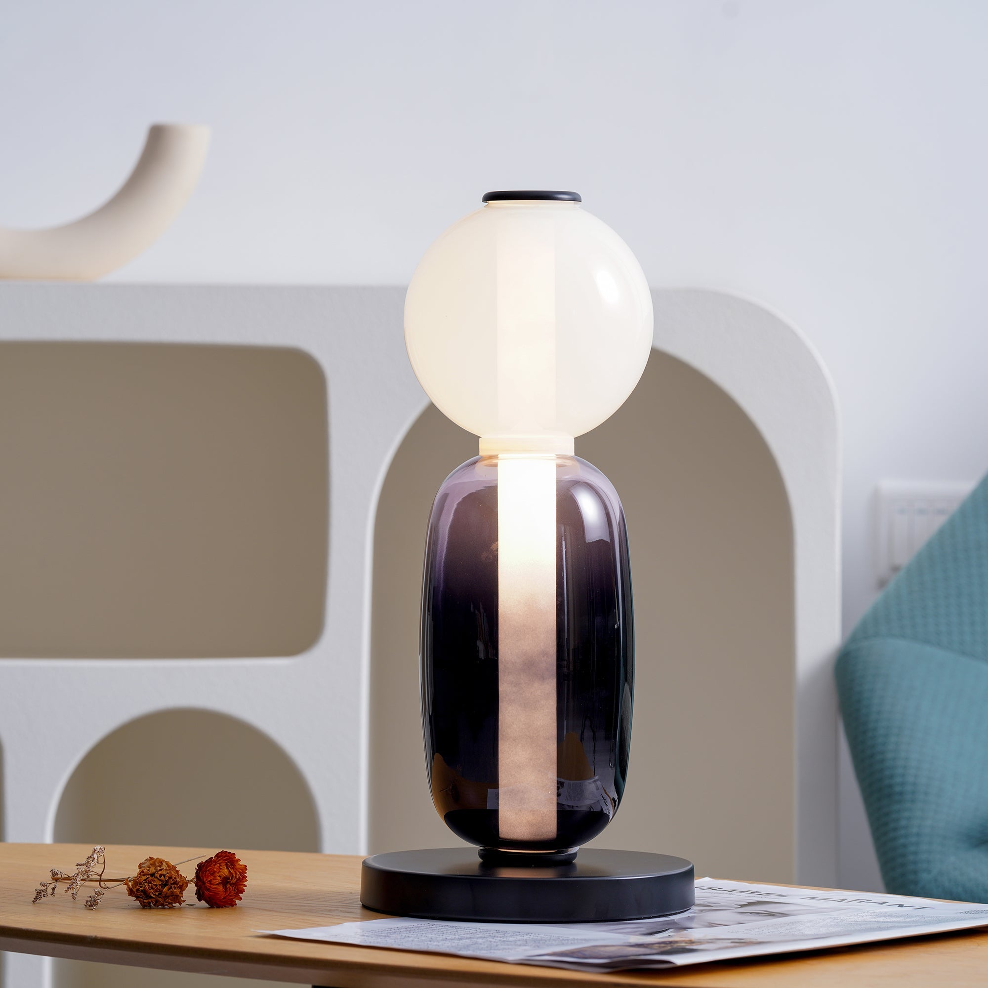 Tall hand-blown glass table lamp standing on a console