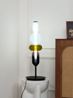Glass cluster table lamp glowing warmly against a dark wall