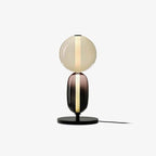 Hand-blown crystal pebble table lamp glowing on a console