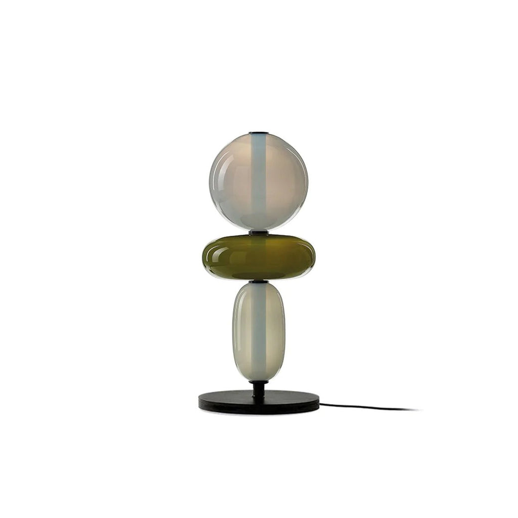 Hand-blown glass pebble table lamp on a bedside table