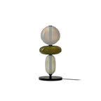 Hand-blown glass pebble table lamp on a bedside table