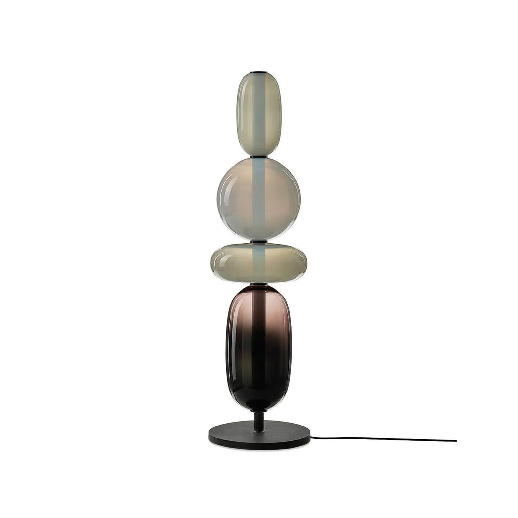 Red hand-blown glass table lamp lit beside a chair