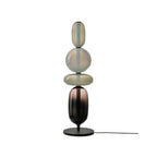 Red hand-blown glass table lamp lit beside a chair