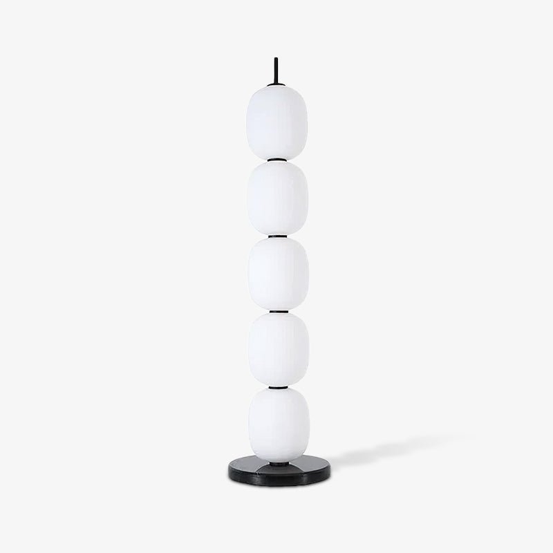The unlit lamp small against an off-white studio wall, its shadow falling to the right.