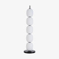 The unlit lamp straight on against plain pale grey, five globes above the marble disc.