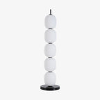 The unlit lamp straight on against plain pale grey, five globes above the marble disc.
