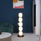 Lit lamp against a navy wall between a green velvet sofa and a tall air conditioning unit.