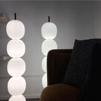 Two lit lamps close up beside an ochre velvet chair, their marble bases out of the frame.