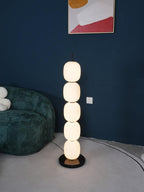 Tight view of the lit lamp against the navy wall, only the edge of the green sofa in frame.