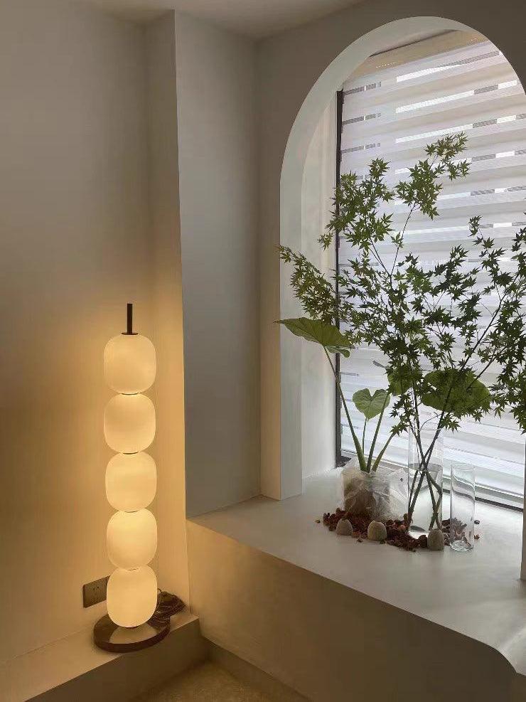 Lit lamp in a plaster alcove, its warm glow on the wall beside an arched window.